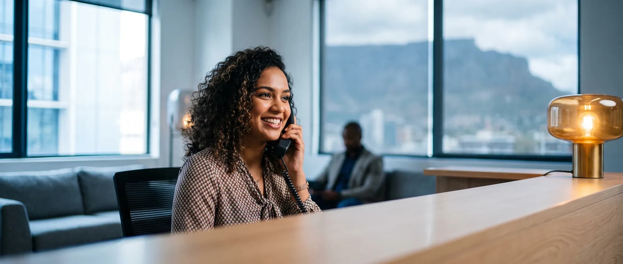 A receptionist answering a desk phone at a professional practice in Cape Town